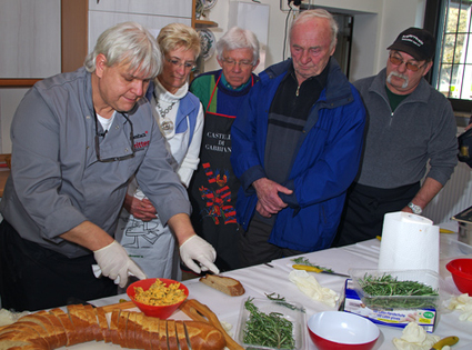 Bild:Frank Huhnke mit Kursteilnehmern bei den Grillvorbereitungen