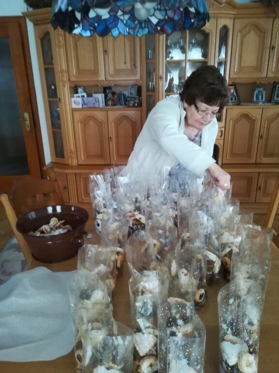 Eine Frau packt zahlreiche Tüten mit Weihnachtsplätzchen