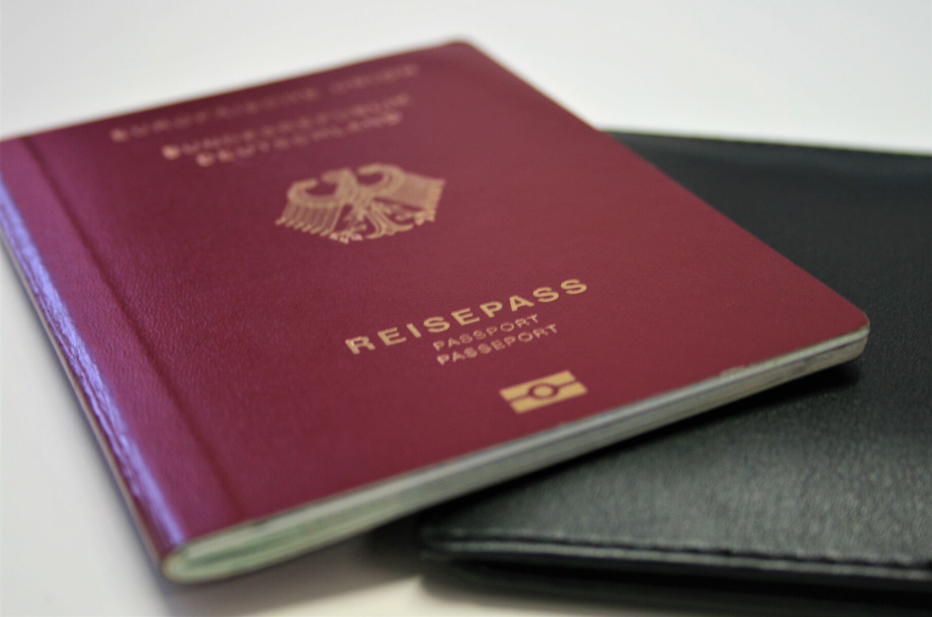 Ein deutscher Reisepass liegt auf einer schwarzen Hülle auf einem Tisch.